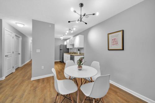 a kitchen and dining room with a white table and chairs at Stonecrest 910, 2bd Apt I Free Parking I Pool in New Albany