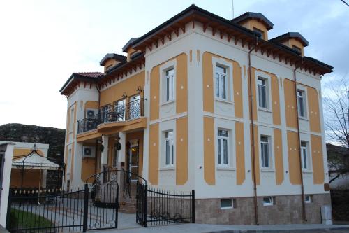 a yellow and white building with a black fence at Villa Paris in Hisarya