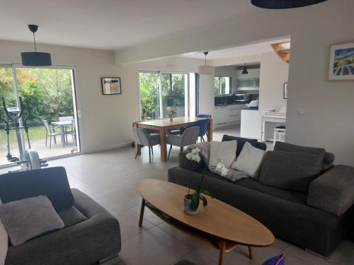 un salon avec deux canapés et une table dans l'établissement Maison de vacances 6 personnes, proche Nantes et mer, à Treillières
