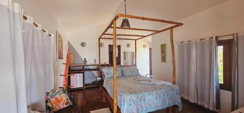 ein Schlafzimmer mit einem Himmelbett in einem Zimmer in der Unterkunft Pousada TERRA NOVA in Aracati