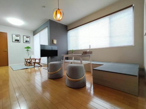 a living room with a table and a television at Alphabed Takamatsustation 301 / Vacation STAY 38150 in Takamatsu