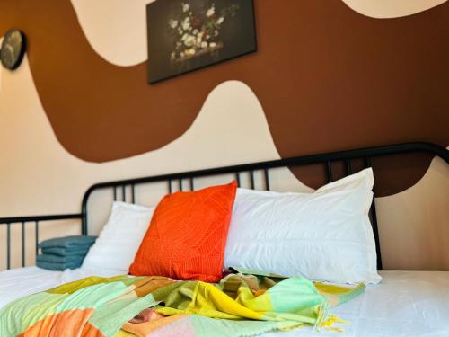 a bed with colorful blankets and pillows on it at The Sun 1 or 3BR Bayan Lepas 4 to 10 pax WL in Bayan Lepas