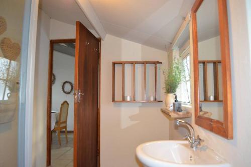 a bathroom with a sink and a mirror at Winecellar Cave, on wine farm & where lions roar! in Stellenbosch