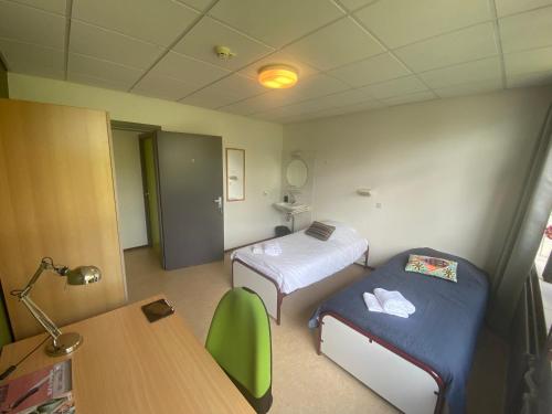 a hospital room with two beds and a table at Het Huis van Bewustzijn in Limmen