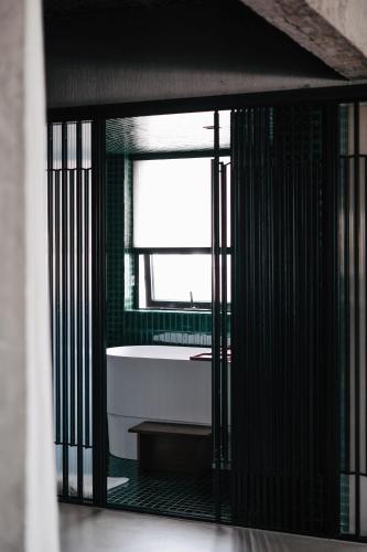 a bathroom with a tub and a window at Jiangnan House Nantou in Shenzhen