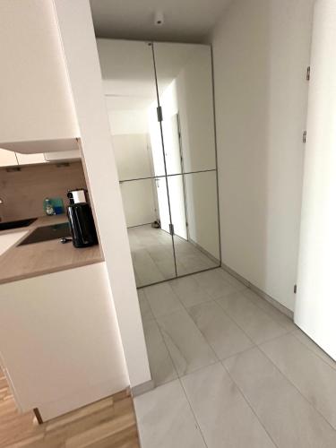 a room with white walls and a glass door at COHO City Apartments mit hauseigener Tiefgarage in Vienna