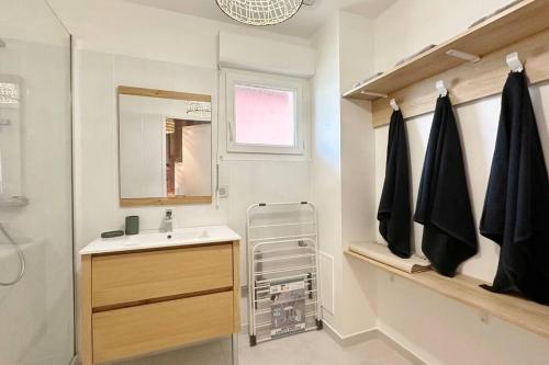 une salle de bain avec un lavabo et un miroir dans l'établissement Spacieux et confortable appartement T3 de 73 m2, à Soorts-Hossegor
