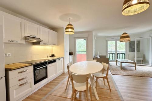une cuisine avec une table et des chaises dans une pièce dans l'établissement Spacieux et confortable appartement T3 de 73 m2, à Soorts-Hossegor
