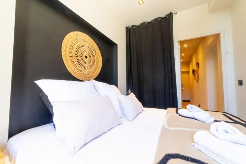 a bedroom with a white bed with a black headboard at Le Charmant d'Ecully Logement Unique Avec Jardin à 10 minutes de Lyon in Écully