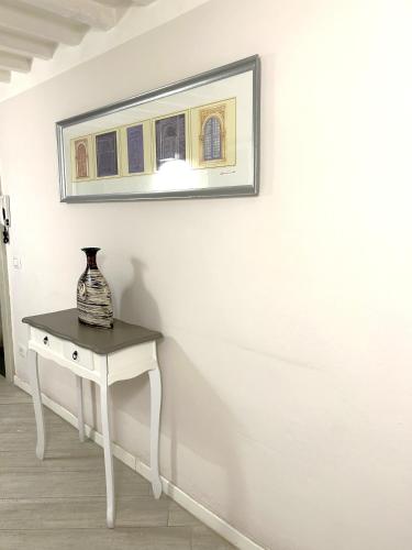 a white table with a vase on top of a wall at Allegra Toscana - Affittacamere Guest house Arezzo in Arezzo