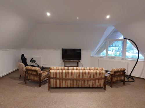 a living room with two couches and a flat screen tv at ALRO Stúdió Apartmanház in Balatonszárszó