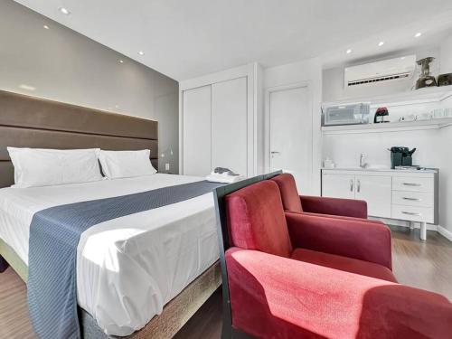 a bedroom with a large bed and a chair at Hotel Itaim Piscina Elegante Prático in Sao Paulo