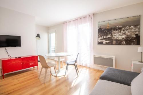 - un salon avec une table et une armoire rouge dans l'établissement Confort et modernité proche de Jean-Jaurès, à Tours