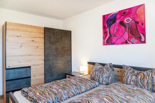a bedroom with a bed and a painting on the wall at Manu's Bergblick in Arzl im Pitztal