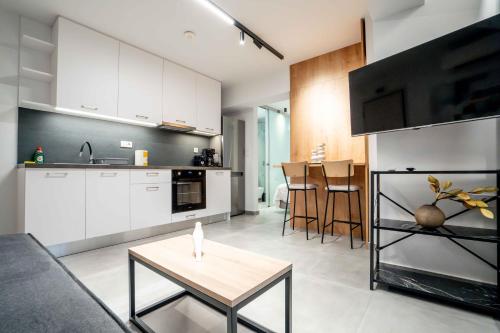 a kitchen with white cabinets and a table in a room at The Nightingale in Ioannina
