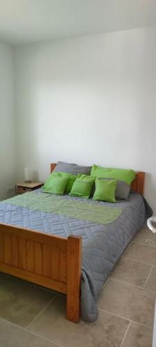 - un lit avec des oreillers verts dans une chambre dans l'établissement Villa Les Hirondelles au Coeur des Vignes D 'Antan, à Mons