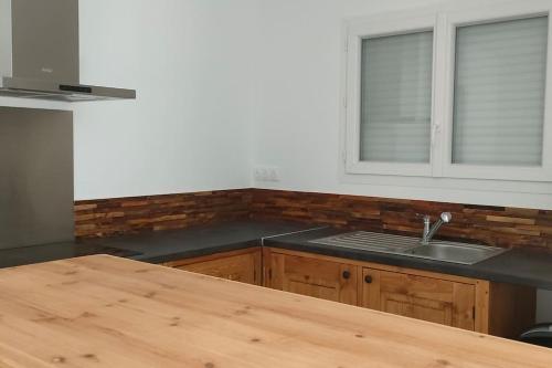 une cuisine avec un comptoir en bois et un évier dans l'établissement Villa Les Hirondelles au Coeur des Vignes D 'Antan, à Mons