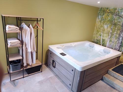 une salle de bain avec une grande baignoire et un porte-serviettes dans l'établissement Gîte Les Tongs des Près, au cœur du Parc Normandie Maine, à Livaie