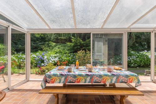 a table in a conservatory with a tablecloth on it at Magnifique Maison Paisible avec Piscine in Jaujac