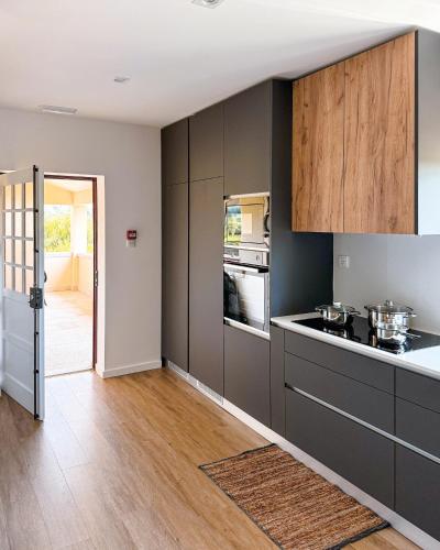 a kitchen with gray cabinets and a counter top at Quinta Dom Sapo - Agroturismo in Viana do Castelo