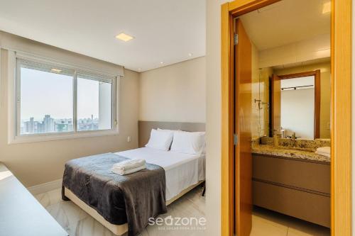 1 dormitorio con 1 cama y baño con ventana en Loft de Luxo c/bela Vista no Petrópolis AHO1402, en Porto Alegre