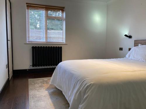 a bedroom with a white bed and a window at 2 bed Serviced Apartment in Henley in Henley on Thames