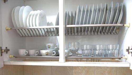 a kitchen shelf with plates and glasses on it at Dimora dei Seclì in Galatina