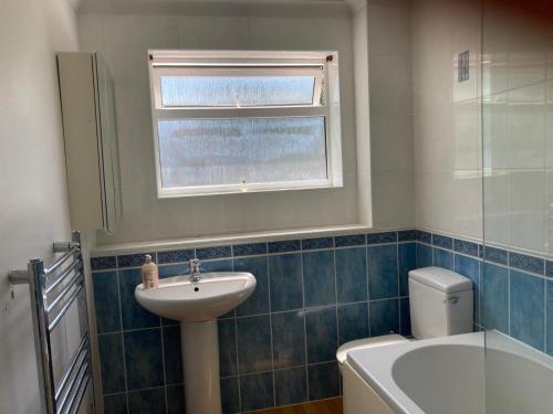 a bathroom with a sink and a toilet and a window at 2 bed Serviced Apartment in Henley in Henley on Thames