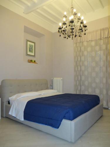 a bedroom with a large bed and a chandelier at Allegra Toscana - Affittacamere Guest house Arezzo in Arezzo