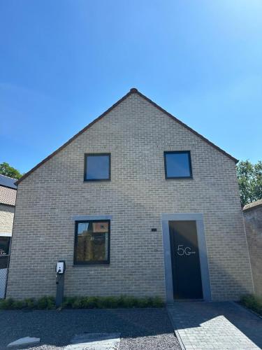 a brick building with a door in front of it at Vakantie aan de Maas - Vakantiewoning Leenhof in Kinrooi