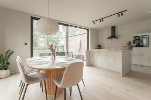 a kitchen and dining room with a table and chairs at Vakantie aan de Maas - Vakantiewoning Leenhof in Kinrooi