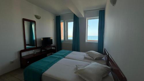 a bedroom with a bed with a mirror and a window at Vila Ilinca in Agigea
