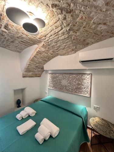 a bedroom with a green bed with towels on it at HOME 5 - Alcova in Putignano