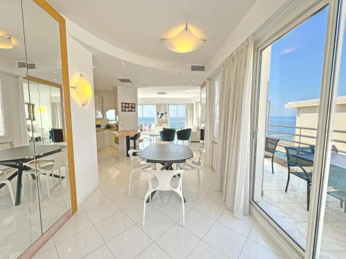 une salle à manger avec une table et une vue sur l'océan dans l'établissement Sea Front Penthouse Cote d Azur, à Nice