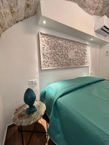 a bedroom with a green bed and a table at HOME 5 - Alcova in Putignano