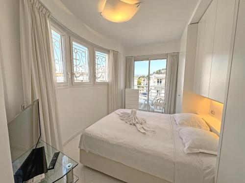 une chambre blanche avec un lit et une fenêtre dans l'établissement Sea Front Penthouse Cote d Azur, à Nice