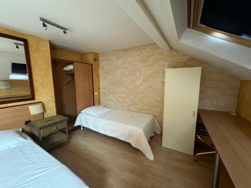 a hotel room with two beds and a mirror at Hôtel Bosquet Pau Centre - Self Check In Budget Hotel in Pau