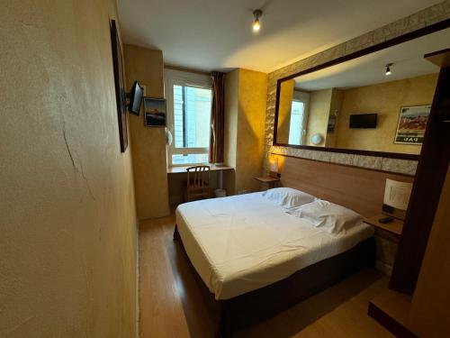 a small bedroom with a bed and a mirror at Hôtel Bosquet Pau Centre - Self Check In Budget Hotel in Pau