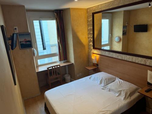 a bedroom with a white bed and a mirror at Hôtel Bosquet Pau Centre - Self Check In Budget Hotel in Pau