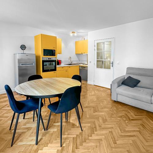 un salon avec une table, des chaises et un canapé dans l'établissement Style et Tranquillité au Kremlin-Bicêtre, au Kremlin-Bicêtre