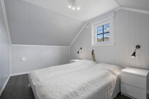 una camera da letto bianca con un letto e una finestra di Velkommen Til Vakre Kvinesdal a Kvinesdal