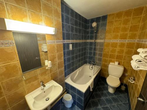 a bathroom with a sink and a toilet and a tub at Hôtel Bosquet Pau Centre - Self Check In Budget Hotel in Pau