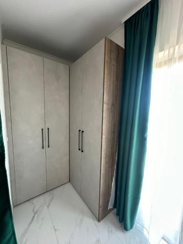 a bedroom with white cabinets and a blue curtain at Hotel Natura Vilanija in Umag