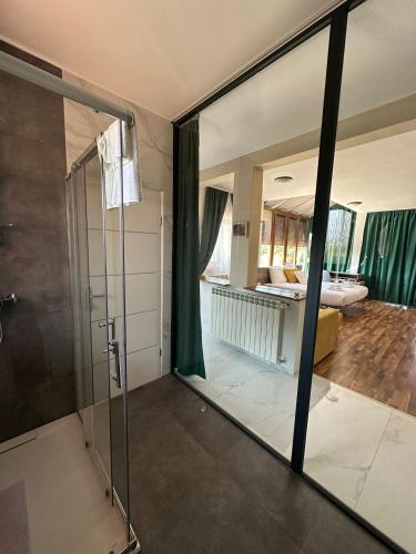 a bathroom with a glass shower and a bedroom at Hotel Natura Vilanija in Umag