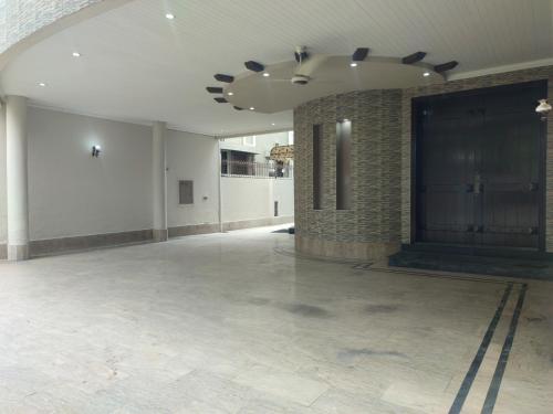 a large empty room with a brick wall and a ceiling at Fully Serviced Holiday Homes Near Emporium Mall & Expo Center in Lahore