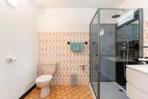 a bathroom with a toilet and a glass shower at La Dame de cœur 05 in Antonaves