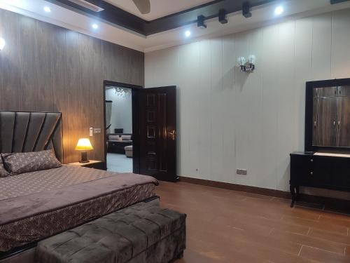 a bedroom with a bed and a couch at Fully Serviced Holiday Homes Near Emporium Mall & Expo Center in Lahore