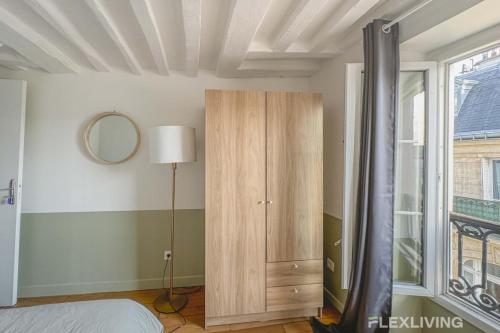 - une chambre avec une armoire en bois et une fenêtre dans l'établissement Flexliving - room - Lune, à Paris