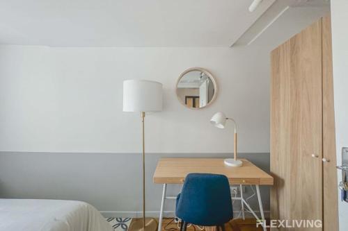 - une chambre avec un bureau et une chaise bleue dans l'établissement Flexliving - room - Lune, à Paris