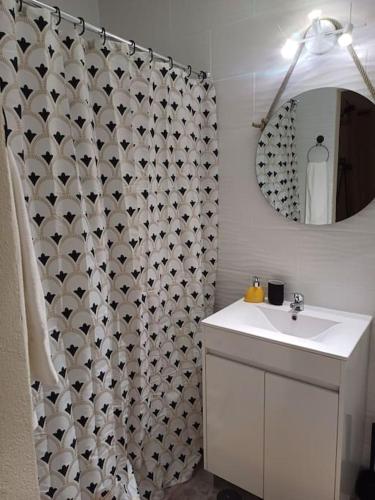 a bathroom with a sink and a shower curtain at Casa Vó Elisa com piscina privada in São Bartolomeu de Messines